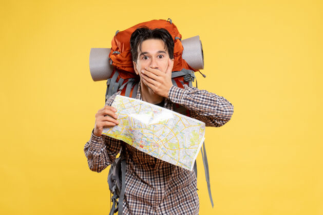 人正面图年轻男子背着黄色背包徒步旅行地图背包旅行