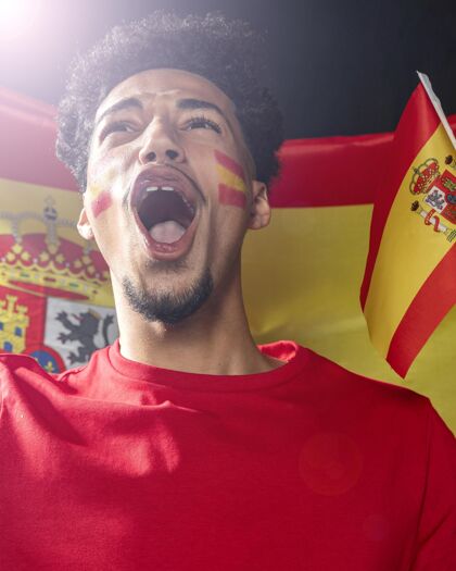 人男子欢呼和举着西班牙国旗的正面图比赛足球比赛公民