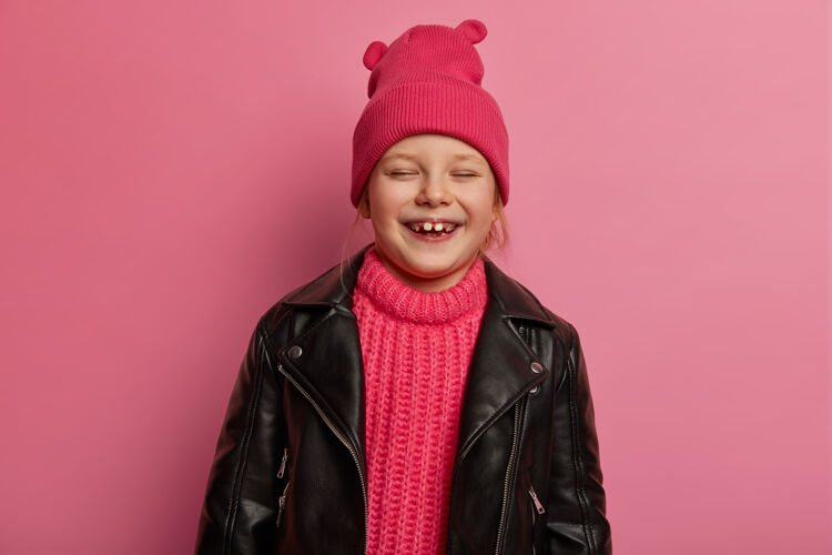 脸孩子 快乐的情感和真挚的情感概念喜出望外的可爱小女孩笑了出来 和父母鬼混 戴着帽子 针织毛衣和泡沫夹克 表达着快乐和幸福请时尚罗西
