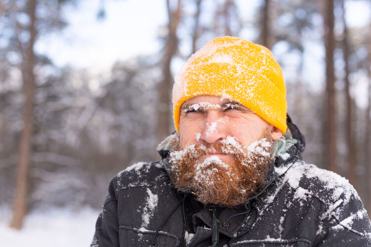 温暖一个留着胡子的成年男子在冬天的森林里 脸都冻在雪里 不高兴地冻着感觉男性冰冻