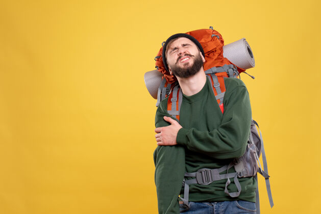 肩膀旅行概念的顶视图与麻烦的年轻人与背包遭受肩膀疼痛痛苦顶肖像