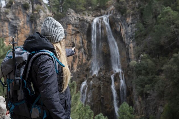 指向背着背包探索大自然的女人瀑布冒险自然