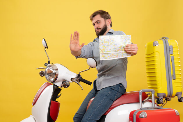 人旅游概念与年轻的情感胡须男子坐在摩托车上 指着前方举行地图上显示五个黄色持有摩托车显示