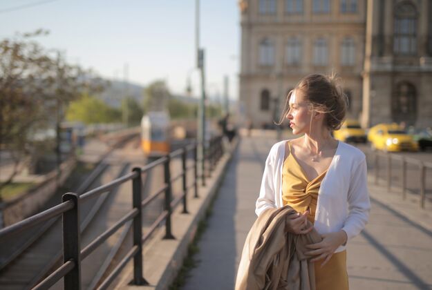 步行匈牙利 一位身着黄色连衣裙的迷人年轻女子在阳光下走过街道城市城市年轻