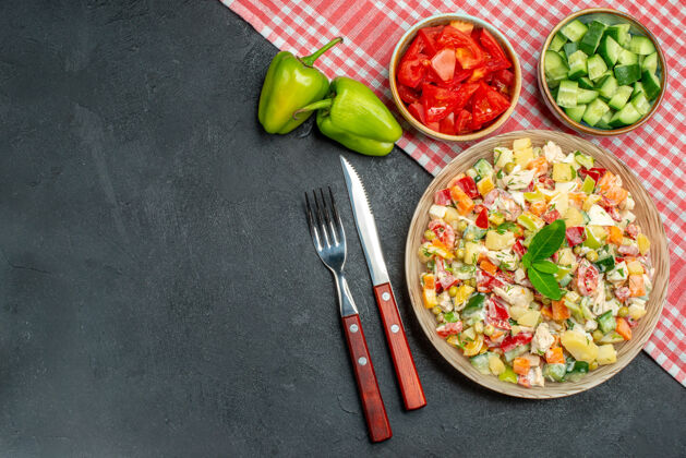 文字蔬菜沙拉的顶视图 碗里有红色餐巾 餐具的侧面有蔬菜 文本放在深灰色的背景上料理胡椒粉膳食