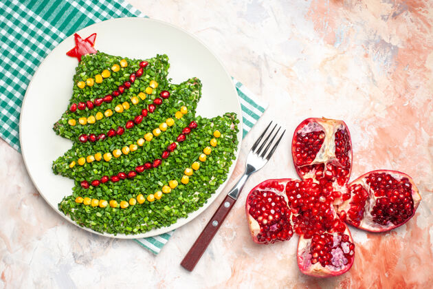 水果顶视图美味的绿色沙拉在新年树形状与石榴光背景树健康胡椒