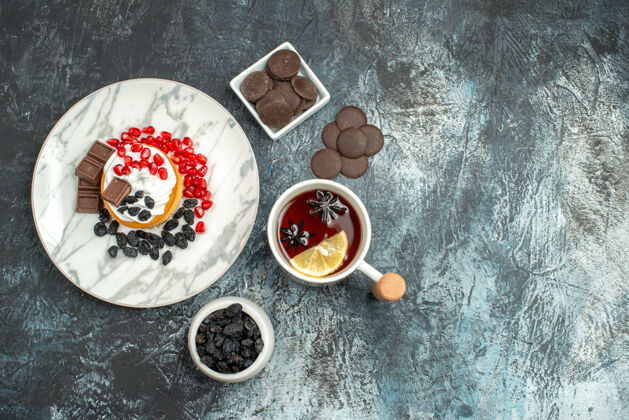 食物顶视图美味的奶油蛋糕与巧克力饼干和茶在浅色背景背景盘子杯子