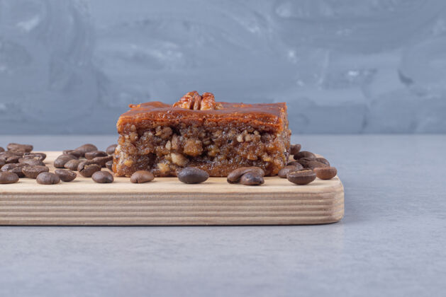 豆类巴克拉瓦和咖啡豆放在大理石上的木板上咖啡美味菜肴