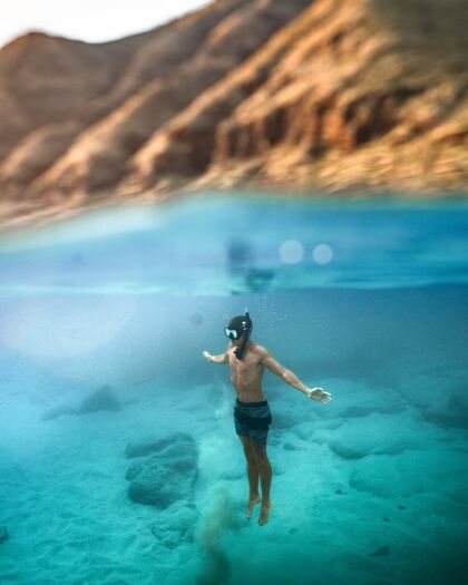 海洋一个男性在绿松石海潜水的垂直镜头潜水休闲自然
