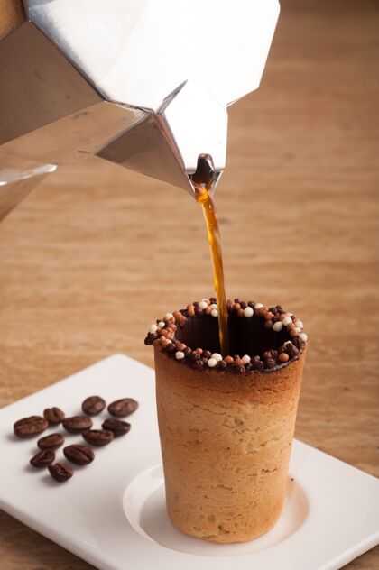垂直垂直选择性聚焦拍摄咖啡倒在饼干制成的杯子里糖食物咖啡