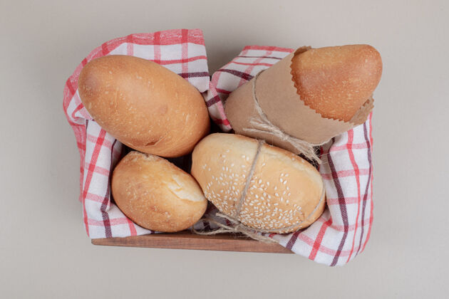 面包用桌布把新鲜的面包糕点放在木篮里糕点木头汉堡
