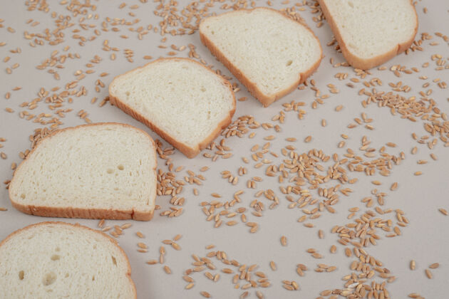 谷物切片新鲜白面包 白面包表面有燕麦粒烘焙美味糕点