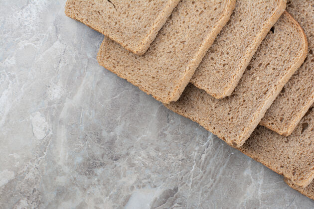 面包在大理石表面放几片棕色面包食品美味膳食
