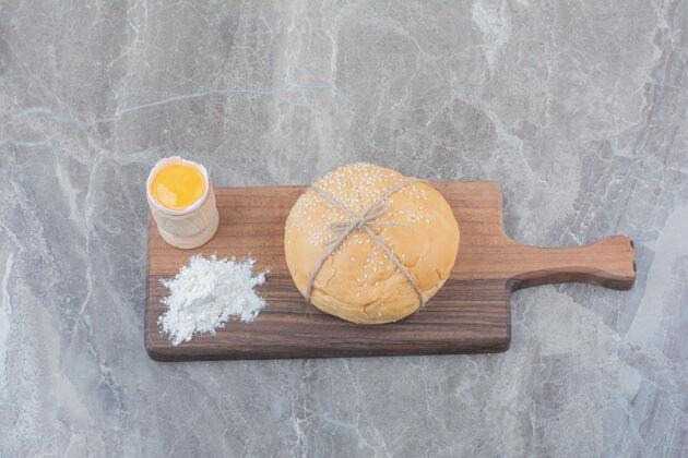 好吃的在木板上放一块蛋黄和面粉的白面包面包房糕点面粉