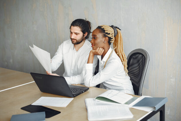 商人穿着白衬衫的帅哥有搭档的非洲女人有笔记本电脑的家伙非洲财务专业