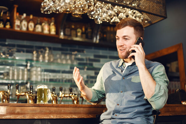 单身中年男人酒吧里拿着电话的男人手机里穿着牛仔衬衫的男人手机手机爱尔兰人