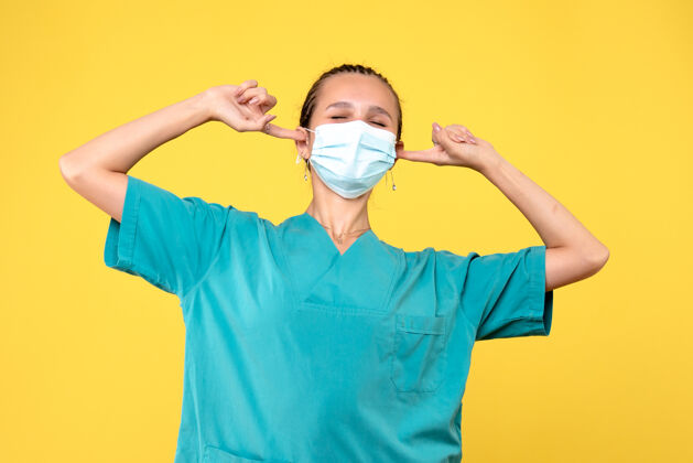 成人正面图：女医生 穿着医用衬衫 戴着口罩 耳朵被堵住了 健康护士 病毒大流行医院 covid-19医生医疗人人