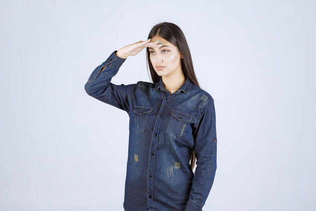 年轻人穿牛仔衫的年轻女子向军人致意女性人类会议