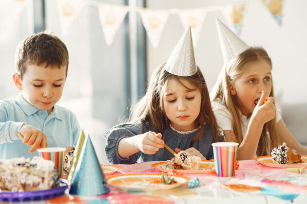 可爱儿童有趣的生日聚会在装饰房间快乐的孩子与蛋糕和气球微笑甜点表情
