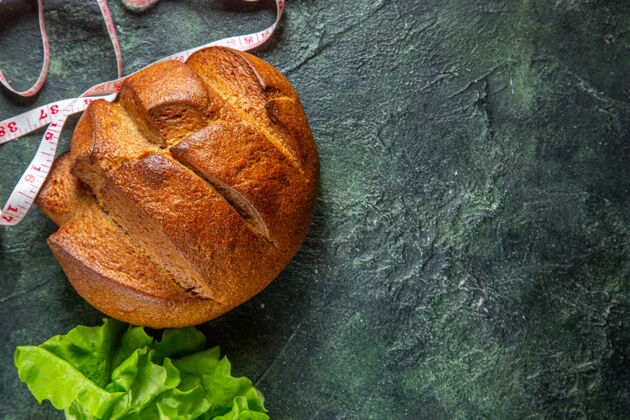 米侧视图饮食黑面包和米绿色捆绑在右侧的深色背景右包黑面包