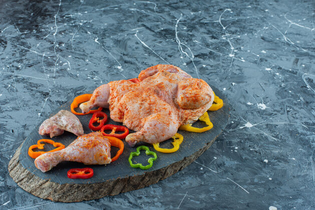 鸡肉准备在蓝色背景的木板上煮鸡肉和胡椒粉美味新鲜鸡腿