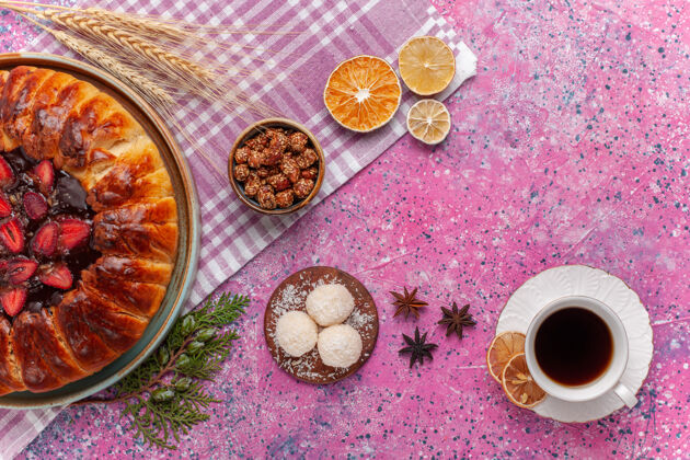肉桂顶视图美味的草莓派水果蛋糕和茶粉红色杯子椰子饼干