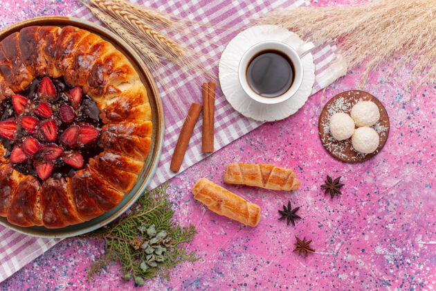 桌子俯瞰美味的草莓派水果蛋糕和浅粉色的茶杯杯子美味食物