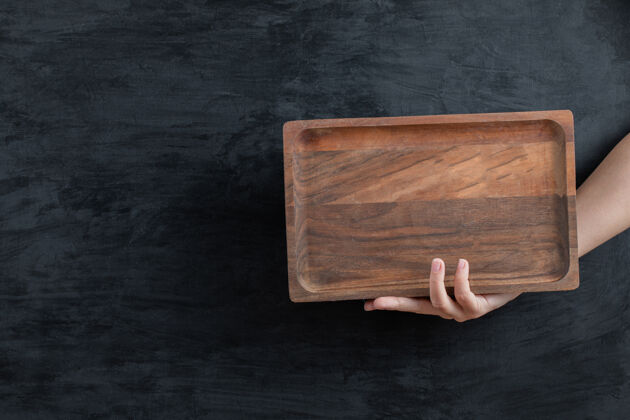 餐具用手拿着一个方形的木盘健康午餐传统