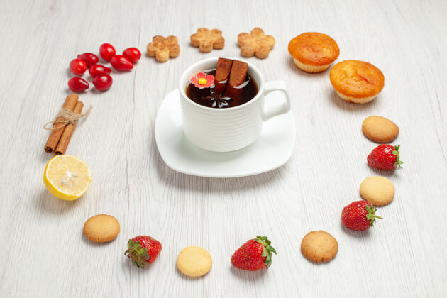 茶前视图一杯茶加水果和饼干放在白色桌面上茶甜点饼干刷新茶杯小吃