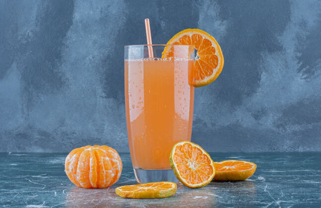 美味甜橙和果汁放在蓝色的桌子上清新柑橘成熟