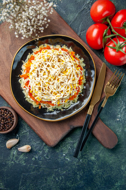 盘子顶视图美味含羞草沙拉在盘子里与深蓝色背景上的红色西红柿风景食物晚餐