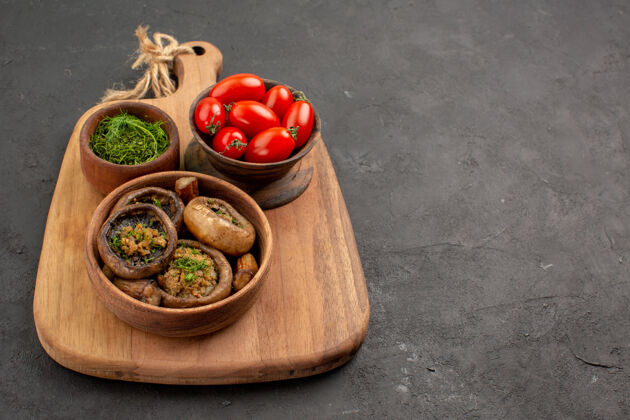 晚餐前视图美味的煮熟蘑菇与番茄和绿色的深色餐桌上的野生熟食碗绿色木头