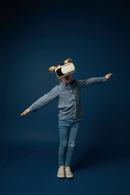 娱乐穿着牛仔裤和衬衫的小女孩戴着虚拟现实耳机眼镜3d游戏女性