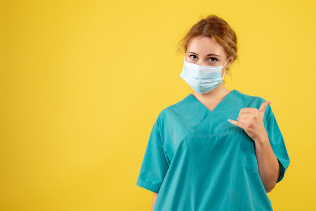 正面黄墙上年轻的女医生穿着医疗服 戴着口罩医疗护士成人