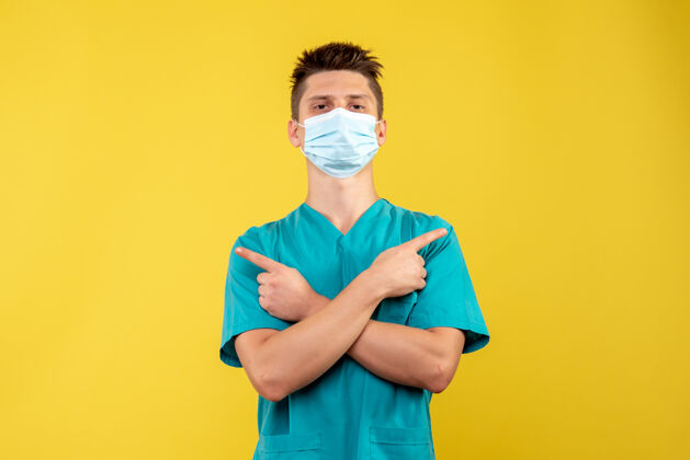 医院黄色墙上戴着防护面具的男医生的正视图疾病漂亮人