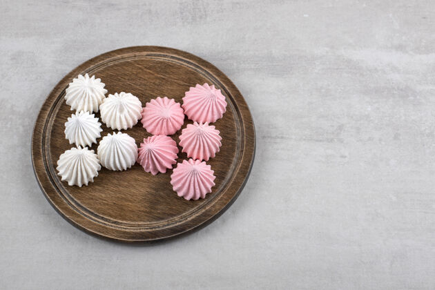 甜点粉色和白色的蛋白酥皮放在木板上 放在大理石桌上卡路里食材配料