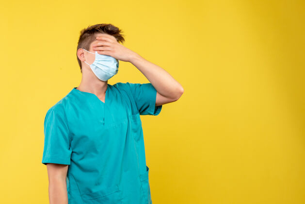 医院黄墙上有男医生穿着医疗服 戴着消毒口罩的正面照片人套装绝育