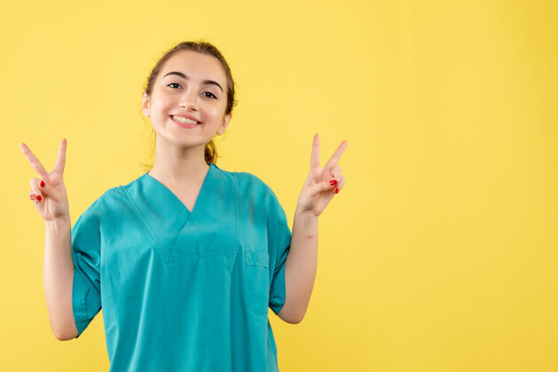 年轻女医生黄墙上年轻女医生身着医疗服的正面图医院套装成人