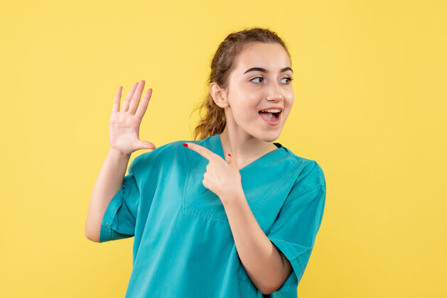 漂亮黄墙上年轻女医生穿着医用衬衫的正面图病毒人健康