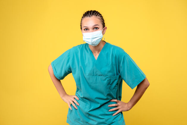 肖像黄墙上穿着医疗服 戴着无菌口罩的女医生的正面图绝育健康面具