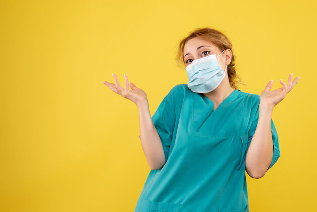 肖像黄墙上穿着医疗服 戴着无菌口罩的女医生的正面图面具病毒人