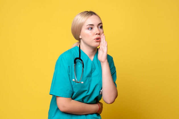 衬衫黄色墙壁上穿着带听诊器的医用衬衫的女医生的正视图听诊器医生护士