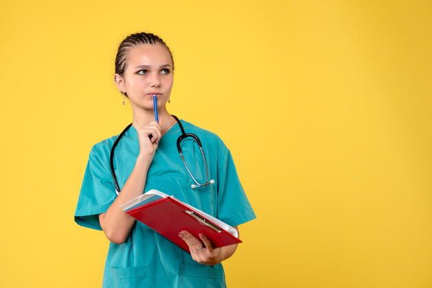 医疗黄色墙壁上穿着不同分析的医疗服的女医生的正面图人护士医院