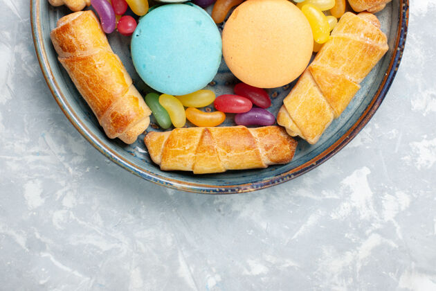 桌子顶视图甜甜的百吉饼和白色的法国马卡龙盘子杏仁饼饼干