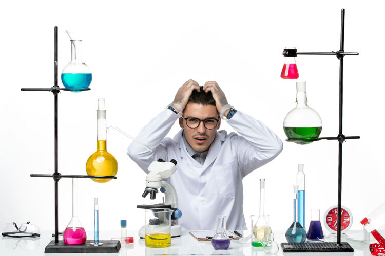 病毒前视图穿着白色医疗服的男性化学家坐在白色背景病毒实验室的解决方案-疾病科学罐子实验医学