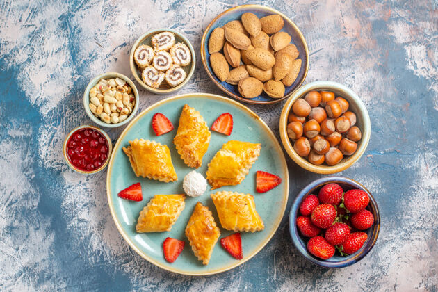 饼干在蓝色背景上俯瞰美味的水果和坚果蛋糕饮食背景早餐
