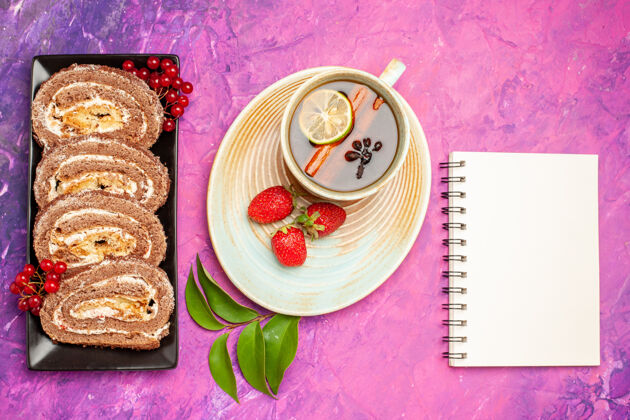 餐顶视图美味饼干卷和一杯茶放在粉红色的桌子上美味早餐杯子