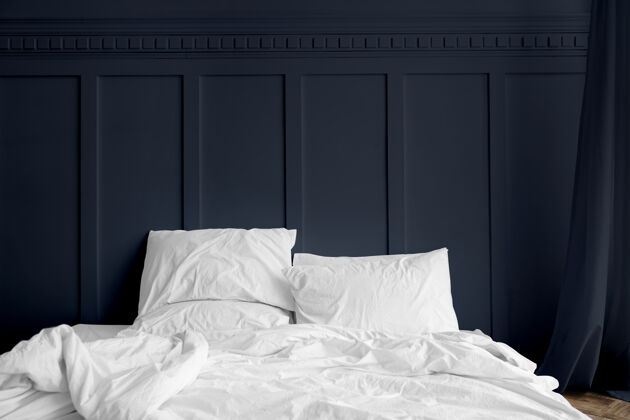 白色床午夜蓝色卧室里床垫上的白色床单干净普通白色毛毯
