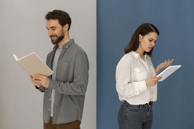 设备背靠背的男人拿着书 女人拿着平板电脑男人女性科技