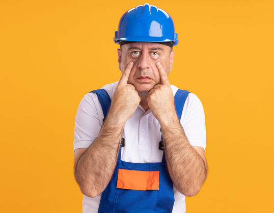 成年人自信的白人成年建筑工人穿着制服拉着橙色的眼皮人拉男人